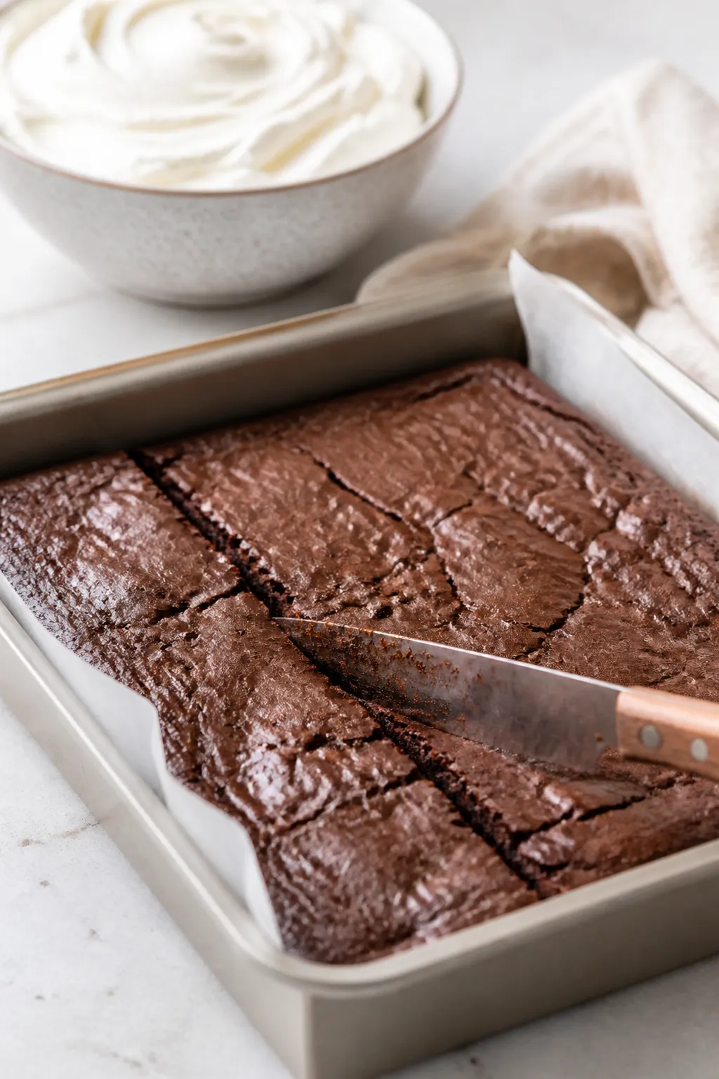 Cooking process close-up: Fudgy brownie slab just cooled in an 8x8-inch parchment-lined pan, surface