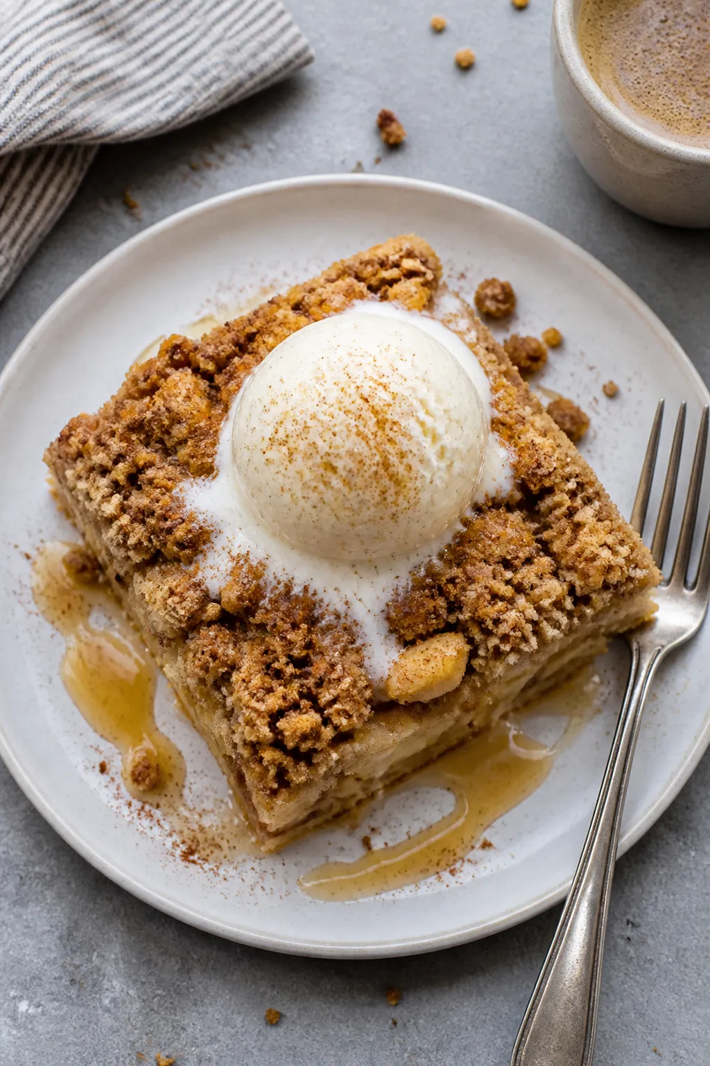 Final plated overhead shot: A generous square slice of apple crumble cake on a matte white plate, se