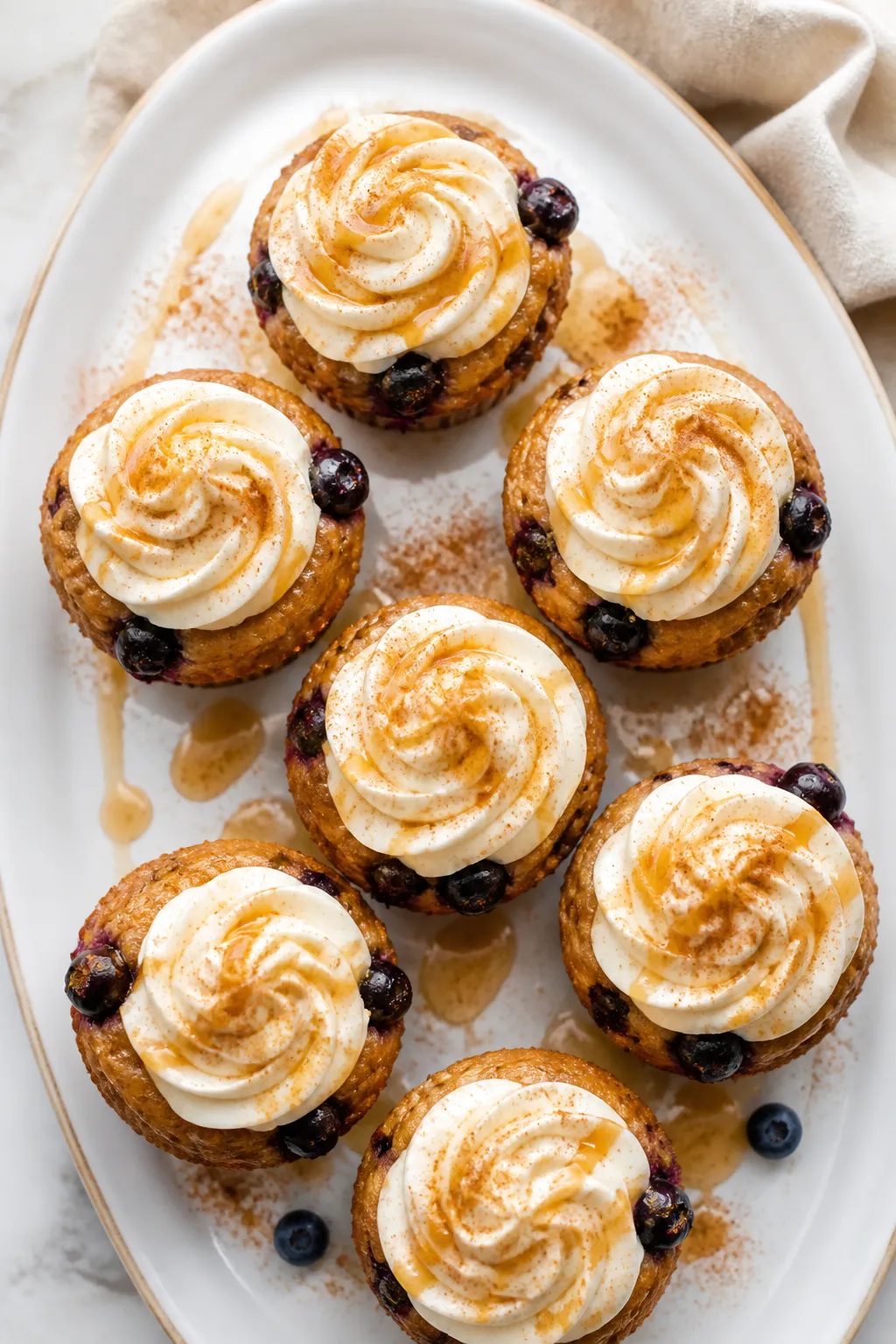 Final plated overhead: Top-down shot of frosted Blueberry French Toast Cupcakes arranged on a white
