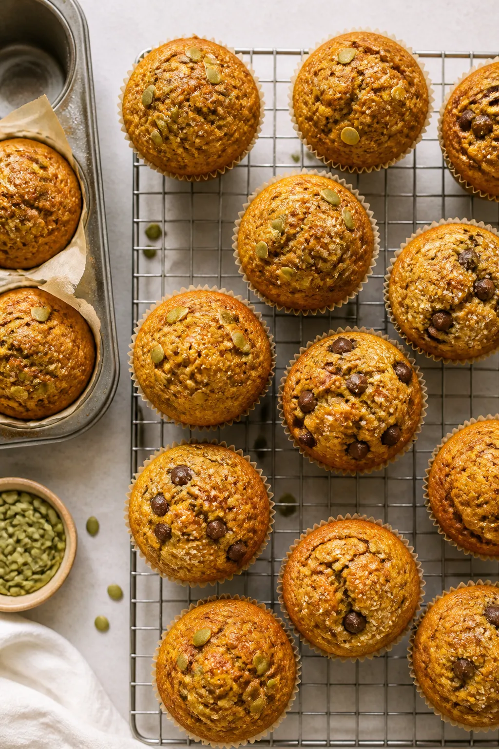 Overhead shot of freshly baked healthy pumpkin muffins cooling on a wire rack, high-domed bakery-sty
