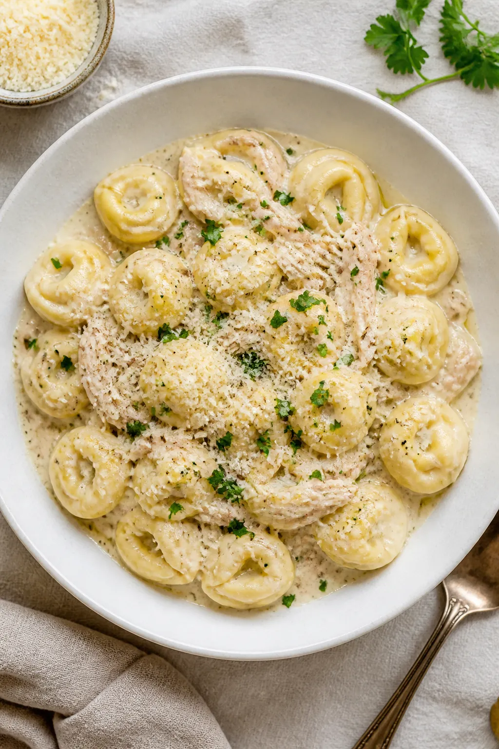 Final plated overhead: Overhead shot of Crockpot Chicken Alfredo Tortellini plated in a wide, shallo